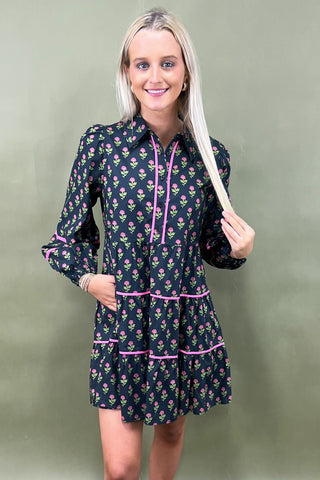 Woman wearing a floral dress with pink accents against a green background