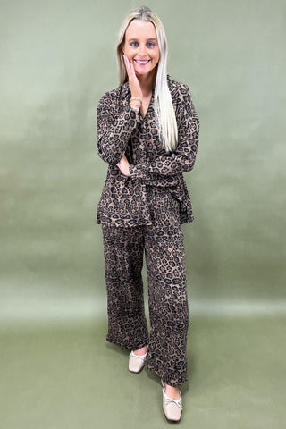 Woman wearing a leopard print outfit against a green background