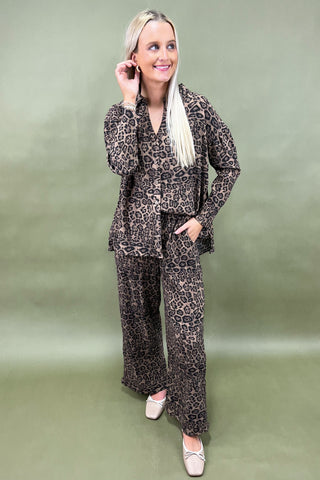 Woman wearing a leopard print outfit against a green background