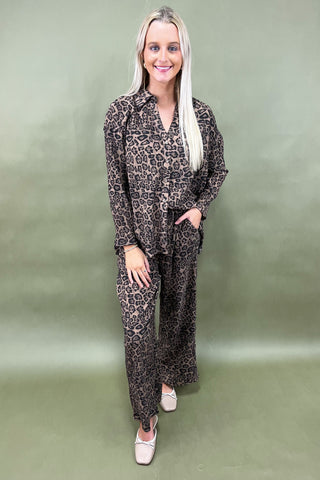 Woman wearing a leopard print outfit on a green background