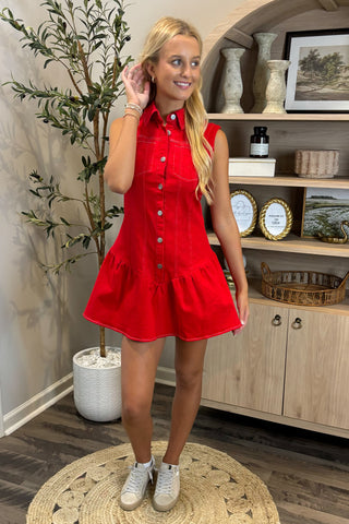 Woman wearing a red dress standing in a room with wooden shelves and decor.