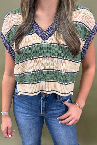 Person wearing a striped sweater and jeans on a plain background