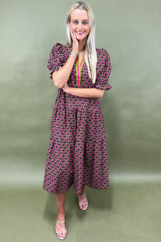 Woman wearing a patterned dress against a green background