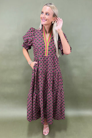Woman wearing a patterned dress against a green background