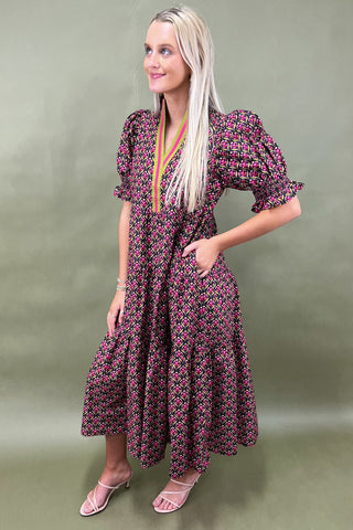 Woman wearing a patterned dress against a green background