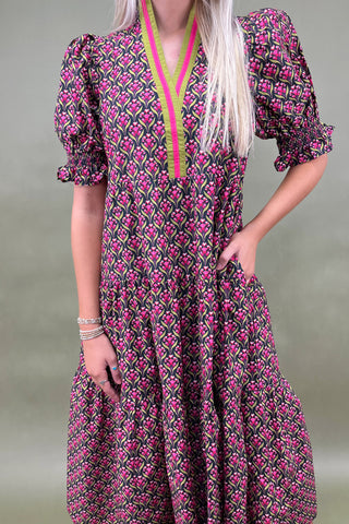 Woman wearing a patterned dress with a plain background