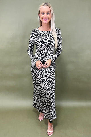 Woman wearing a zebra print dress against a plain background