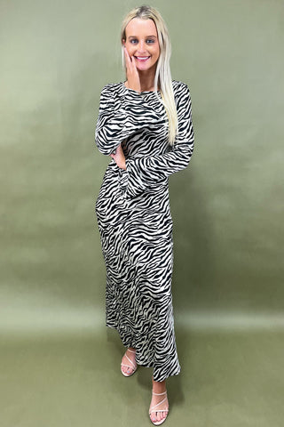 Woman wearing a zebra print dress against a green background