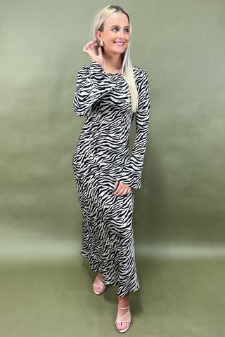 Woman wearing a zebra print dress against a green background