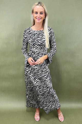 Woman wearing a zebra print dress against a green background