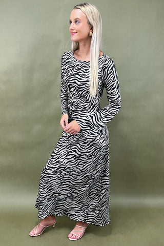 Woman wearing a zebra print dress against a green background