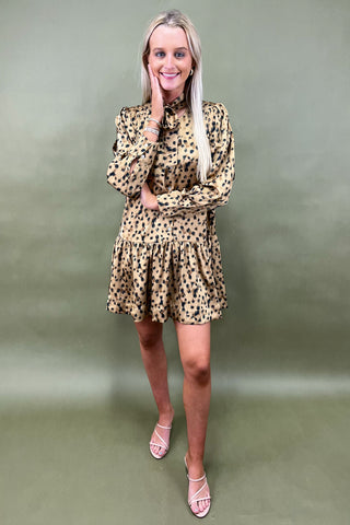 Woman wearing a leopard print dress against a green background
