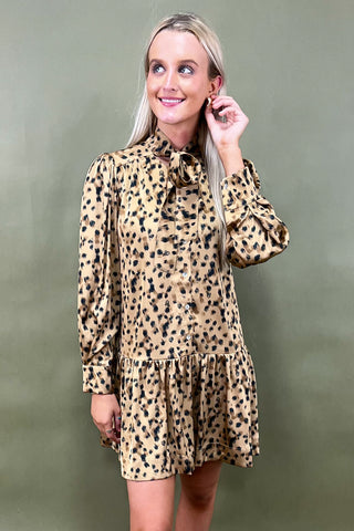 Woman wearing a leopard print dress against a green background