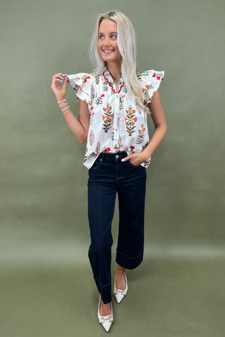 White floral ruffle sleeve blouse with button front styled with dark wide leg cropped jeans and white pointed loafers