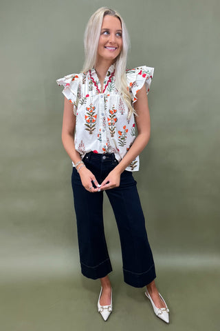 White floral ruffle sleeve blouse with button front styled with dark wide leg cropped jeans and white pointed loafers