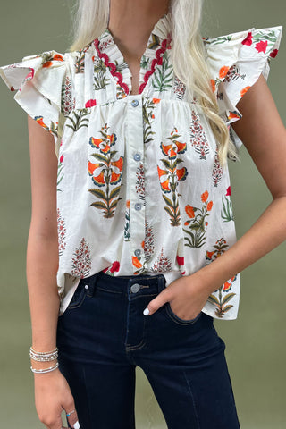 White floral ruffle sleeve blouse with button front styled with dark wide leg cropped jeans and white pointed loafers