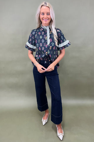Black floral ruffle sleeve blouse with striped trim details styled with dark wide leg cropped jeans and white pointed loafers