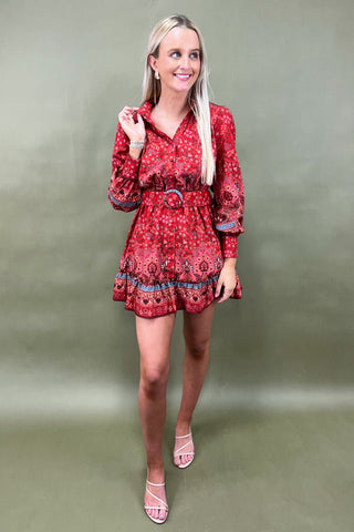 Woman wearing a red patterned dress against a green background