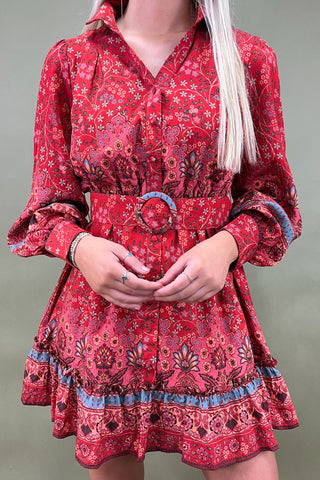 Red patterned dress worn by a person on a plain background