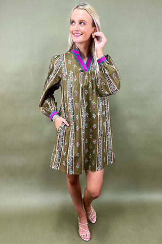 Woman wearing a green patterned dress against a green background