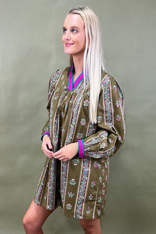 Woman wearing a patterned dress against a plain background