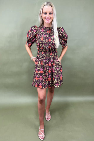 Woman wearing a floral dress against a green background