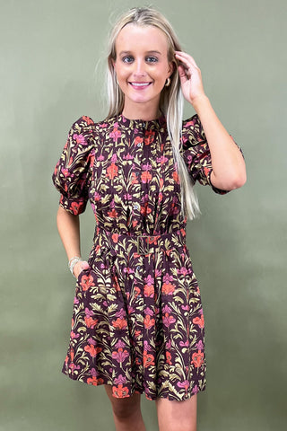 Woman wearing a floral dress against a green background