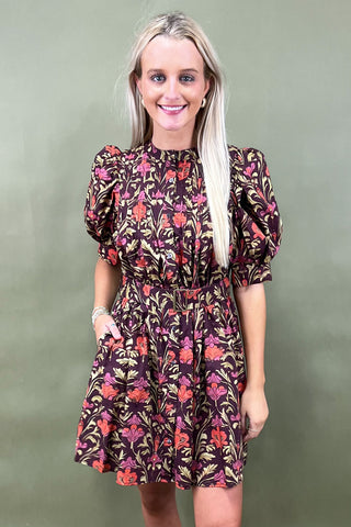 Woman wearing a floral dress against a plain background