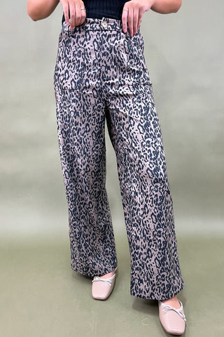 Leopard print pants worn by a person on a plain background