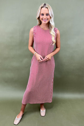 Woman wearing a red and white striped dress against a green background