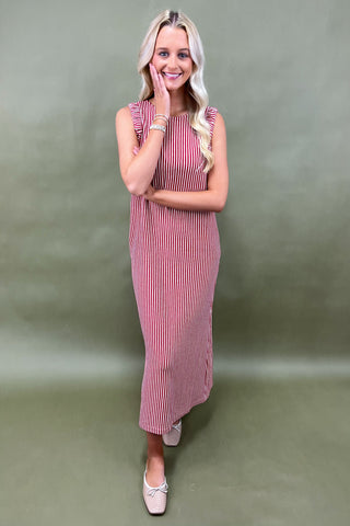 Woman wearing a pink striped dress against a plain background