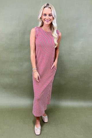 Woman wearing a red and white striped dress against a green background