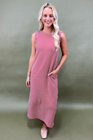 Woman wearing a red and white striped dress against a plain background