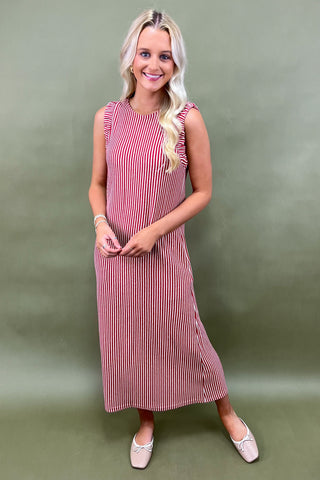 Woman wearing a red and white striped dress against a green background