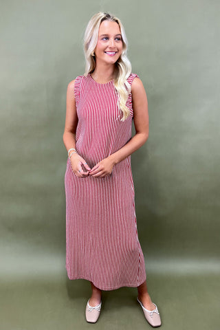 Woman wearing a red and white striped dress against a green background