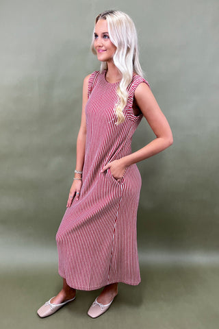 Woman wearing a pink striped dress against a green background