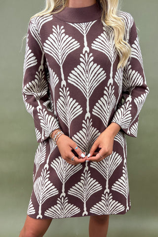 Brown dress with white leaf pattern worn by a person against a green background