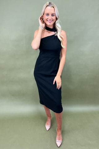 Woman wearing a black one-shoulder dress against a green background