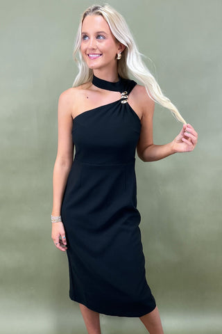 Woman wearing a black one-shoulder dress against a plain background