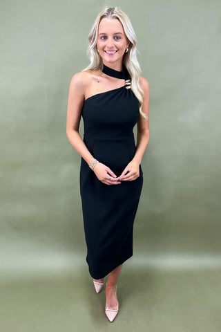 Woman wearing a black one-shoulder dress against a green background