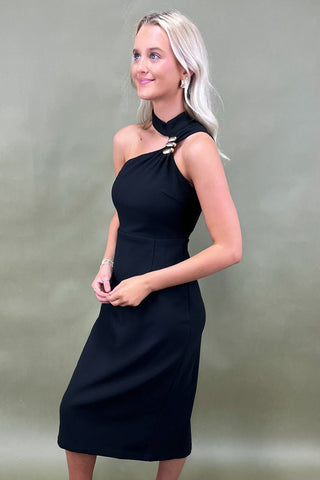 Woman wearing a black dress against a plain background