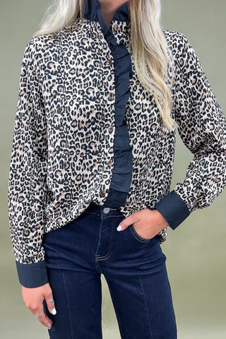 Woman wearing a black and white striped romper against a blue background