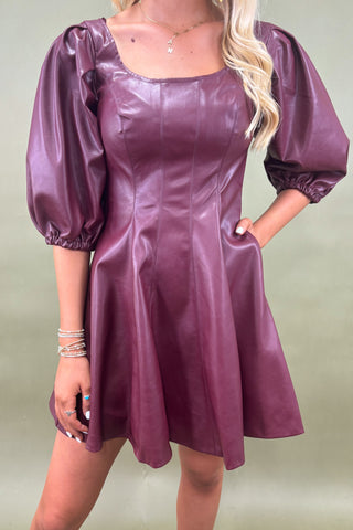 Woman wearing a black and white striped romper against a blue background