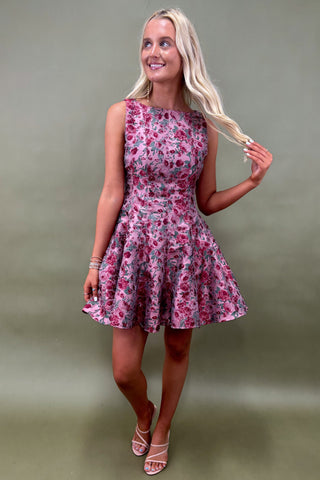 Woman wearing a floral dress against a plain background