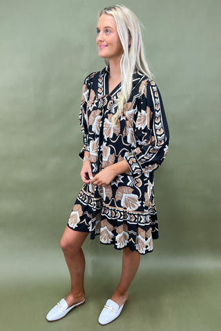 Woman wearing a patterned dress against a green background