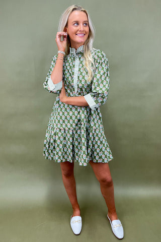 Woman wearing a green floral dress against a green background