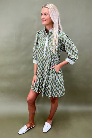 Woman wearing a green floral dress against a green background