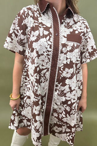 Brown and white floral patterned shirt worn by a person on a green background