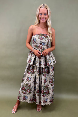 Woman wearing a floral strapless dress against a green background