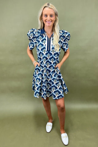 Woman wearing a blue floral dress against a green background